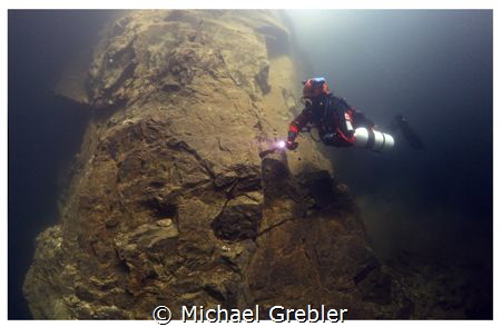 A side-mount diver descends along one of the supporting r... by Michael Grebler 