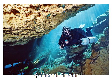 Side-mount diver entering the cavern section at Peacock S... by Michael Grebler 
