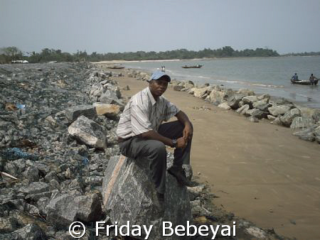I am at the sea bank of the costal rock looking my countr... by Friday Bebeyai 