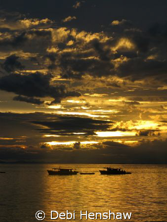 Sunset looking over dive boats moored off Mabul Island. S... by Debi Henshaw 
