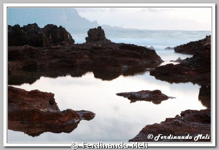 A mirror effect of the beach rocks. by Ferdinando Meli 