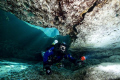 My dive buddy poking his head into a cave in FL with sunrays lighting the entry. 