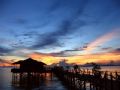 Sunset over cosy water chalets of Kapalai. Waves for songs and sunset on the endless horizon for a view. Entirely built on shallow waters in the middle of the sea. Taken using Canon Powershot A95.