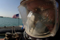 Navy Diver takes a moment to pray before entering the waters of the Arabian Gulf to conduct a ships husbandry dive on a submarine.