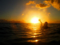 	A buddy and I were doing an underwater shoot. When we surfaced, this sunset was displaying. That is my buddy with his underwater camera gear.